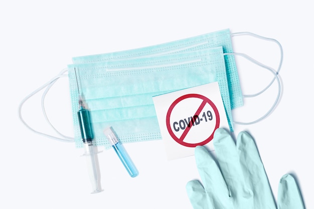 Jeringa, estetoscopio, guante y máscara médica con signo de prevención del coronavirus