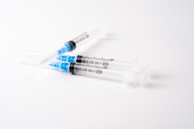 Jeringa médica aislado sobre fondo blanco con aguja azul