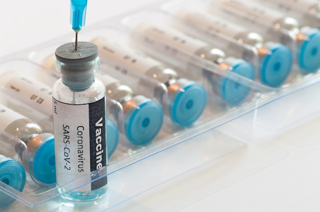 Jeringa médica con ampolla de vidrio con vacuna contra el coronavirus COVID-19