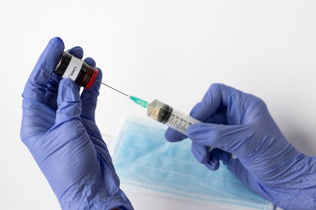 Jeringa con vacuna líquida en manos de un médico. Medecina, vacuna contra coronavirus. COVID-19