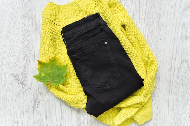 Jersey amarillo verdoso y jeans negros. Concepto de moda