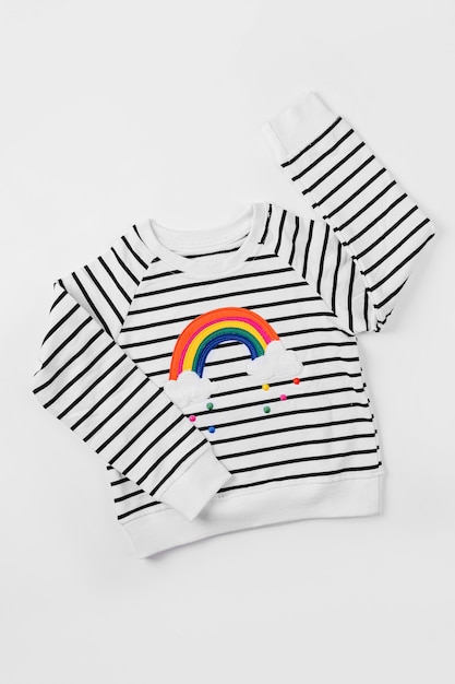 Jersey de rayas con arcoíris sobre fondo blanco. Traje de niños lindos. Ropa infantil para otoño o primavera.