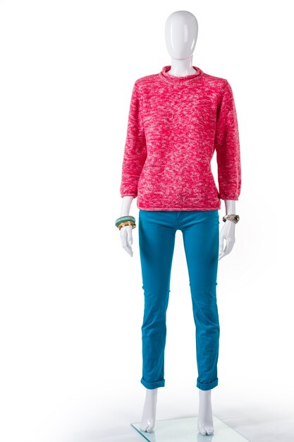 Jersey rosa y pantalón turquesa. Maniquí de mujer con sudadera rosa. Atuendo de señora de moda para la primavera. Jersey de manga larga en escaparate.