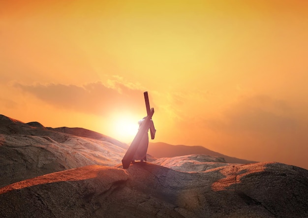 Jesus carregando a cruz do sofrimento que simboliza a luz e as nuvens da colina ao pôr do sol e