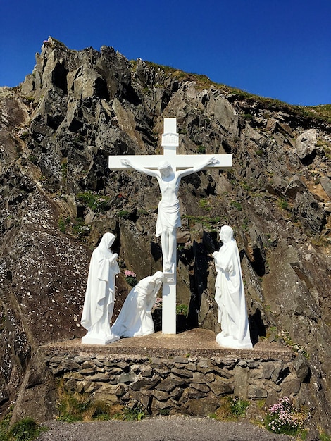 Jesus-Christus-Statue am Kreuz gegen den Berg