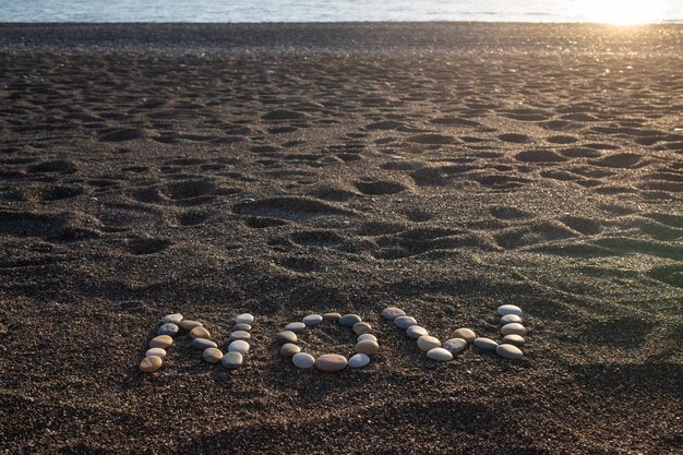 Jetzt Wort aus Formsteinen am Sandstrand