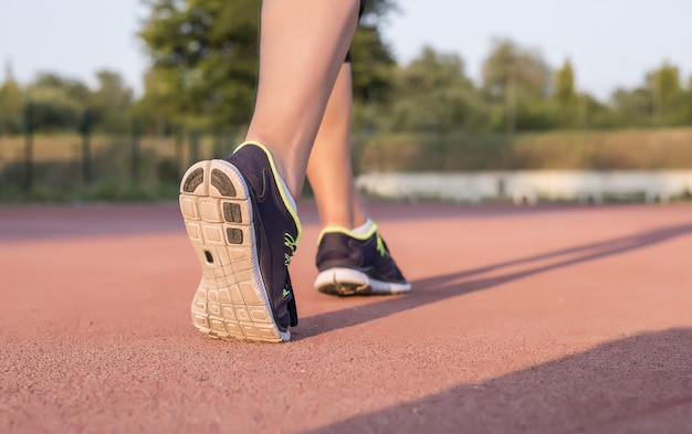 Jigger-Frau trägt Turnschuhe und joggt auf dem Boden