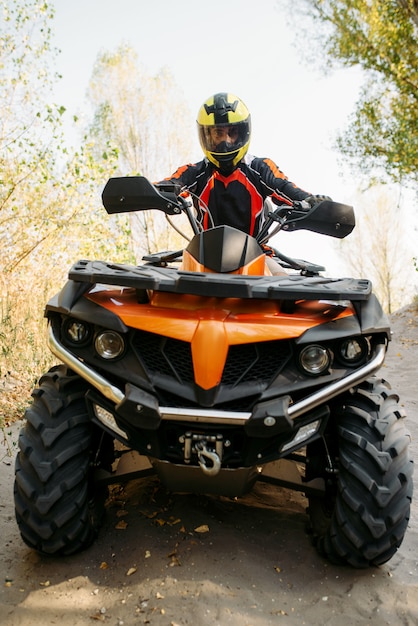 Jinete en casco en quad, vista frontal, primer plano