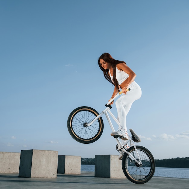 Jinete femenino está en la bicicleta durante el día cerca del lago