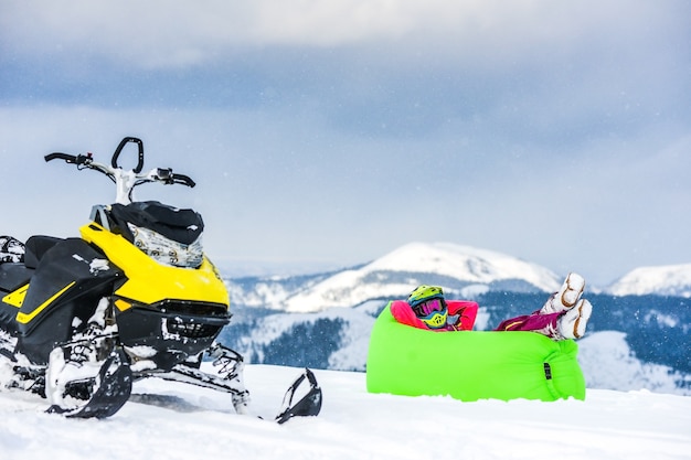 Jinete en la moto de nieve en las montañas