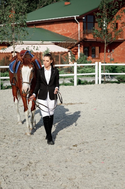 Jinete mujer elegante montando su caballo afuera