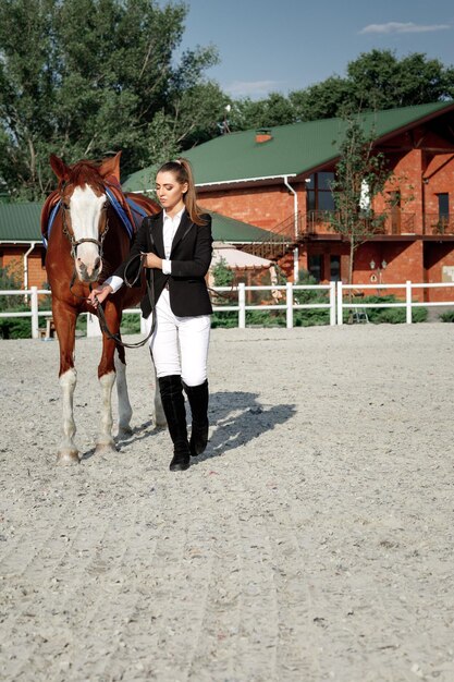 Jinete mujer elegante montando su caballo afuera