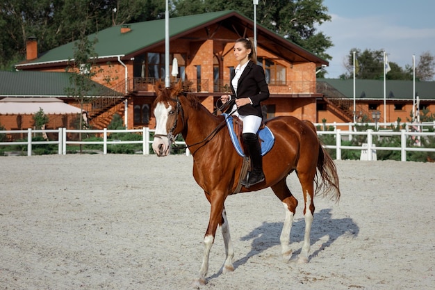 Jinete mujer elegante montando su caballo afuera