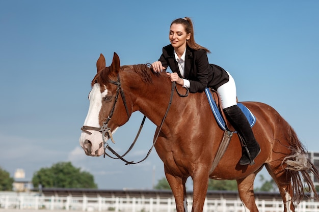 Jinete mujer elegante montando su caballo afuera