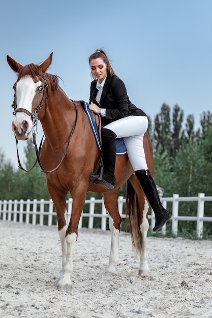 Jinete mujer elegante montando su caballo afuera