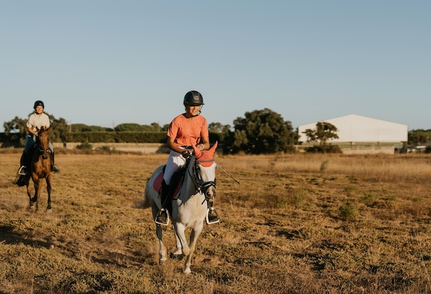 Jinete vestido de rosa mientras su caballo blanco cabalga frente a otro jinete