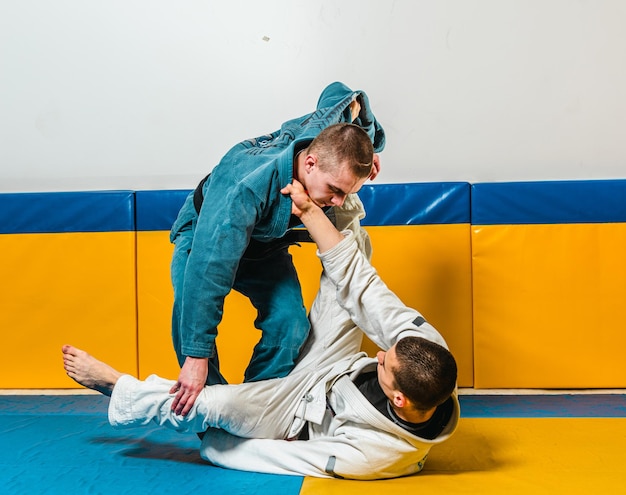 Foto jiujitsu brasileño y entrenamiento de grappling para hombres en un gimnasio de defensa personal