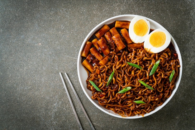 Jjajang Rabokki - Fideos instantáneos coreanos o Ramyeon con pastel de arroz coreano o Tteokbokki y huevo en salsa de frijol negro - Estilo de comida coreana