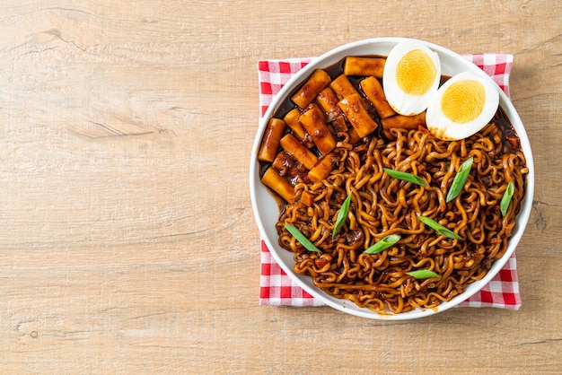 Jjajang Rabokki – Koreanische Instantnudeln oder Ramyeon mit koreanischem Reiskuchen oder Tteokbokki und Ei in schwarzer Bohnensauce – Koreanisches Essen