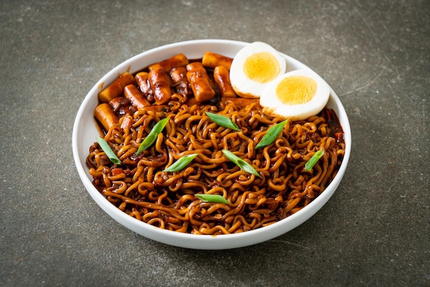 Jjajang Rabokki – Koreanische Instantnudeln oder Ramyeon mit koreanischem Reiskuchen oder Tteokbokki und Ei in schwarzer Bohnensauce – Koreanisches Essen