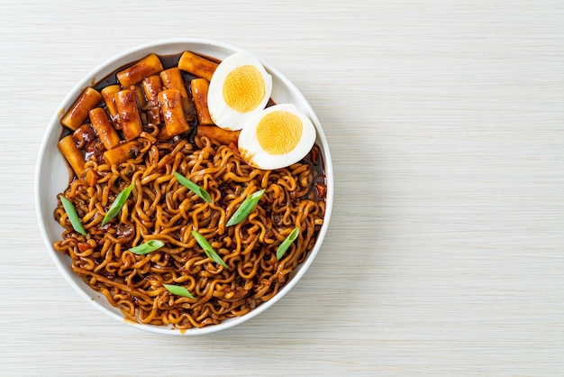 Jjajang Rabokki – Koreanische Instantnudeln oder Ramyeon mit koreanischem Reiskuchen oder Tteokbokki und Ei in schwarzer Bohnensauce – Koreanisches Essen
