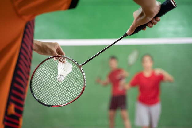 Jogador de badminton segurando uma peteca pronta para servir