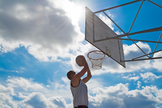 Jogador de basquete atirando sob um céu nublado