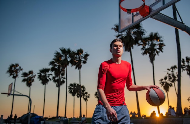 Jogador de basquete Esportes e basquete Céu do pôr-do-sol e campo ao fundo