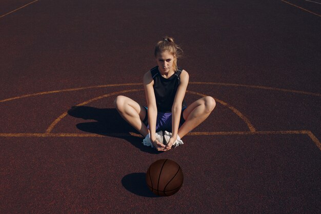 Jogador de basquete jovem aquecendo antes do jogo de streetball