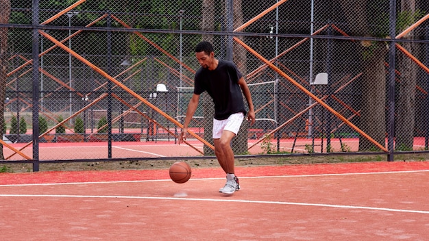 Jogador de basquete negro jogando no campo