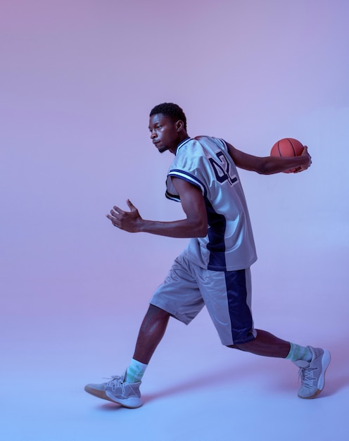 Jogador de basquete praticando com bola. Baller masculino profissional em sportswear, jogando o jogo de esporte.