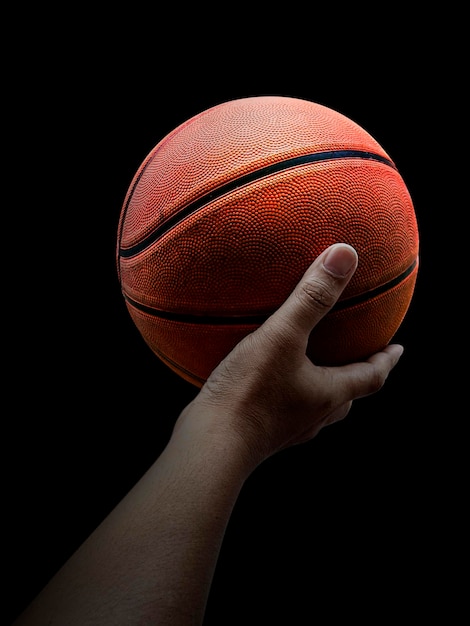 Jogador de basquete segurando uma bola contra o fundo preto