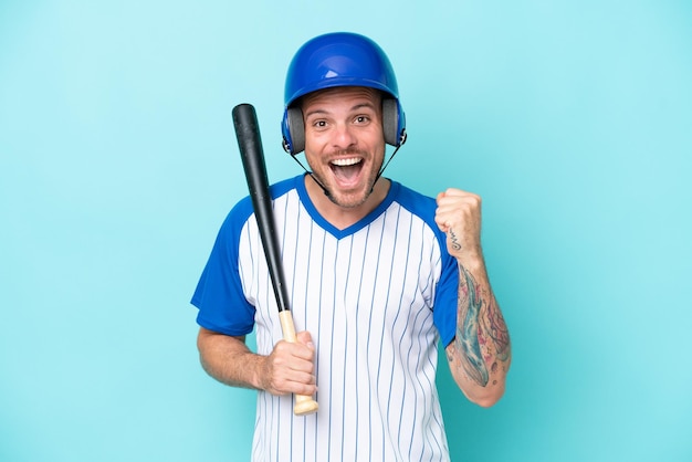 Jogador de beisebol com capacete e taco isolado em fundo azul comemorando uma vitória na posição de vencedor