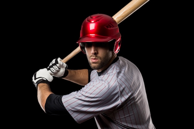 Jogador de beisebol em um fundo preto. Tiro do estúdio.