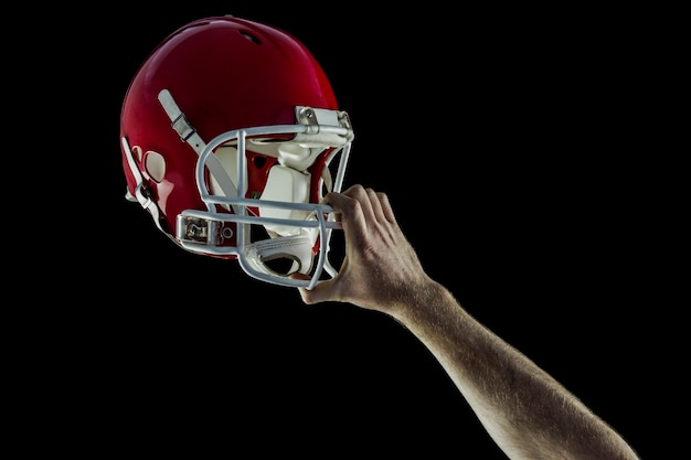 Jogador de futebol americano segurando seu capacete