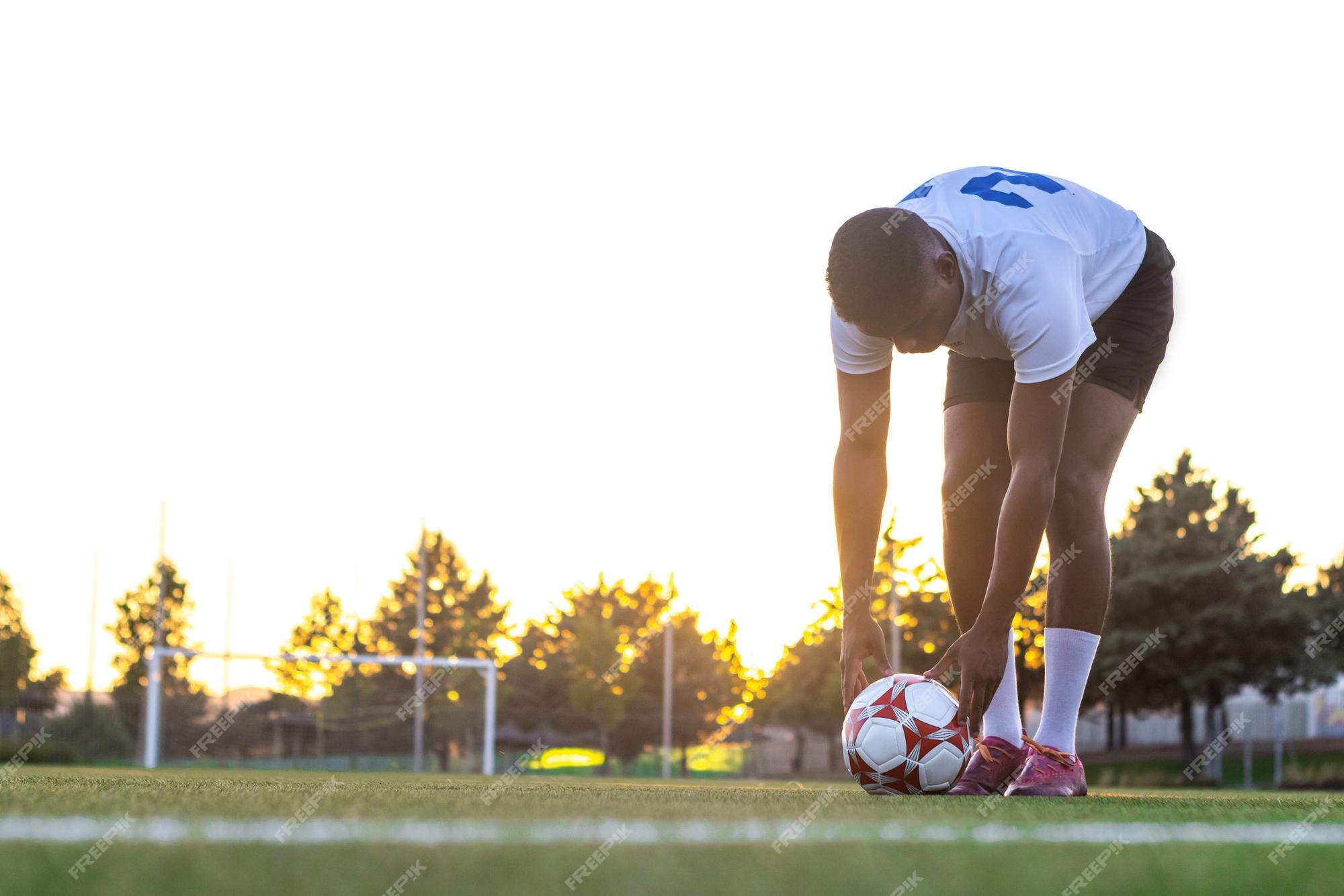 Jogador de futebol em azul saltando contra visão de ângulo baixo