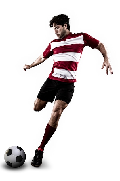 Jogador de futebol com um chute de uniforme vermelho.