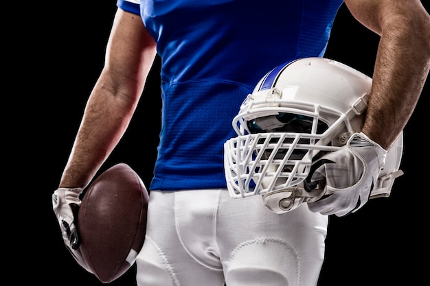 Jogador de futebol com uniforme azul em parede preta