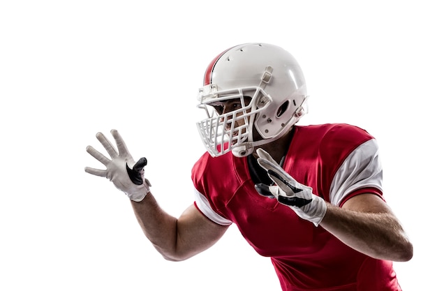 Jogador de futebol com uniforme vermelho fazendo um tackle no branco