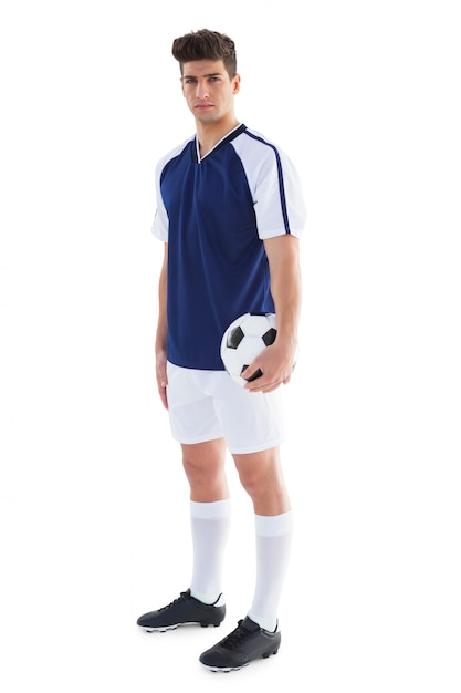 Jogador de futebol em azul jersey segurando bola