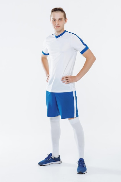 Jogador de futebol em uniforme branco e azul contra um fundo branco