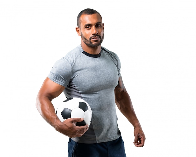 Jogador de futebol forte com bola de futebol no fundo branco isolado