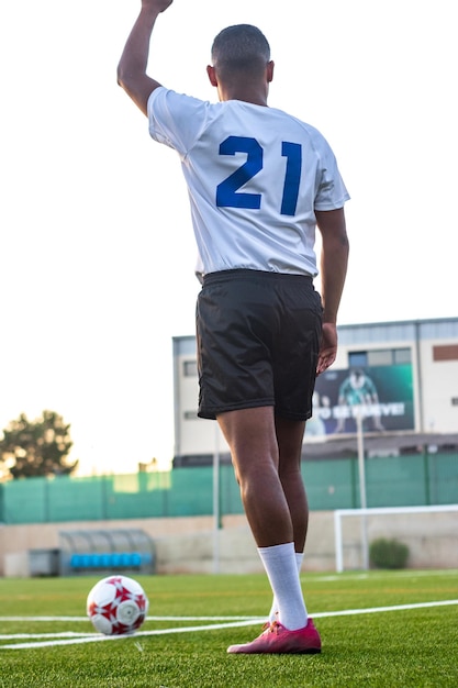 Jogador de futebol latino marcando a estratégia antes de marcar um escanteio em um campo de futebol