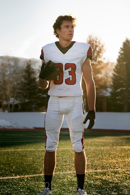 Jogador de futebol masculino americano de uniforme no campo