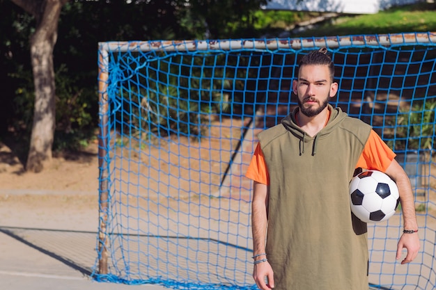 Jogador de futebol na frente do gol com a bola