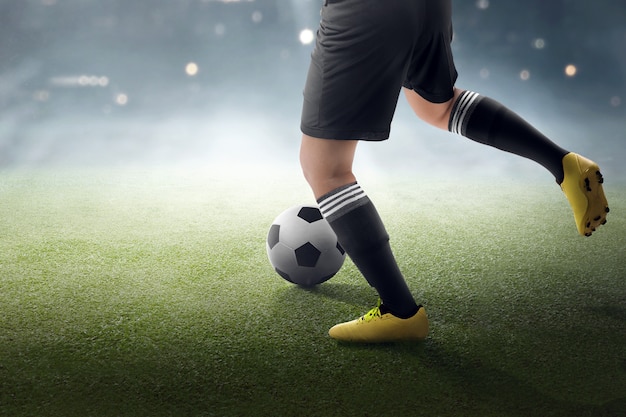 Jogador de futebol tentando chutar a bola