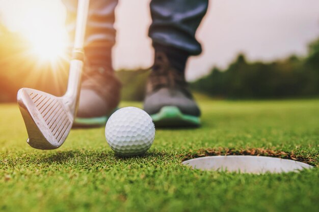 jogador de golfe colocando bola de golfe no buraco