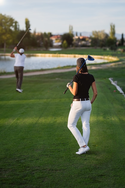 Jogador de golfe da mulher que espera sua vez ao tee de