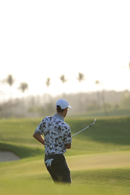 Jogador de golfe masculino jovem no campo de golfe