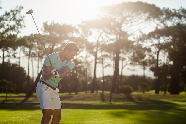 Jogador de golfe masculino que toma o tiro